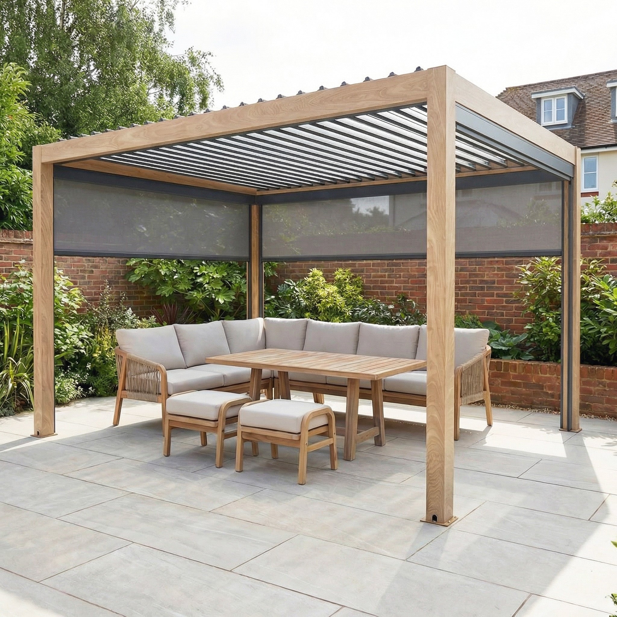 The PergoSTET Plus 3m x 4m Rectangular Pergola with wood effect, 3 manual side blinds, and LED lighting creates a stylish outdoor space—shown here with a gray sofa set, chairs, and table on a tiled patio.