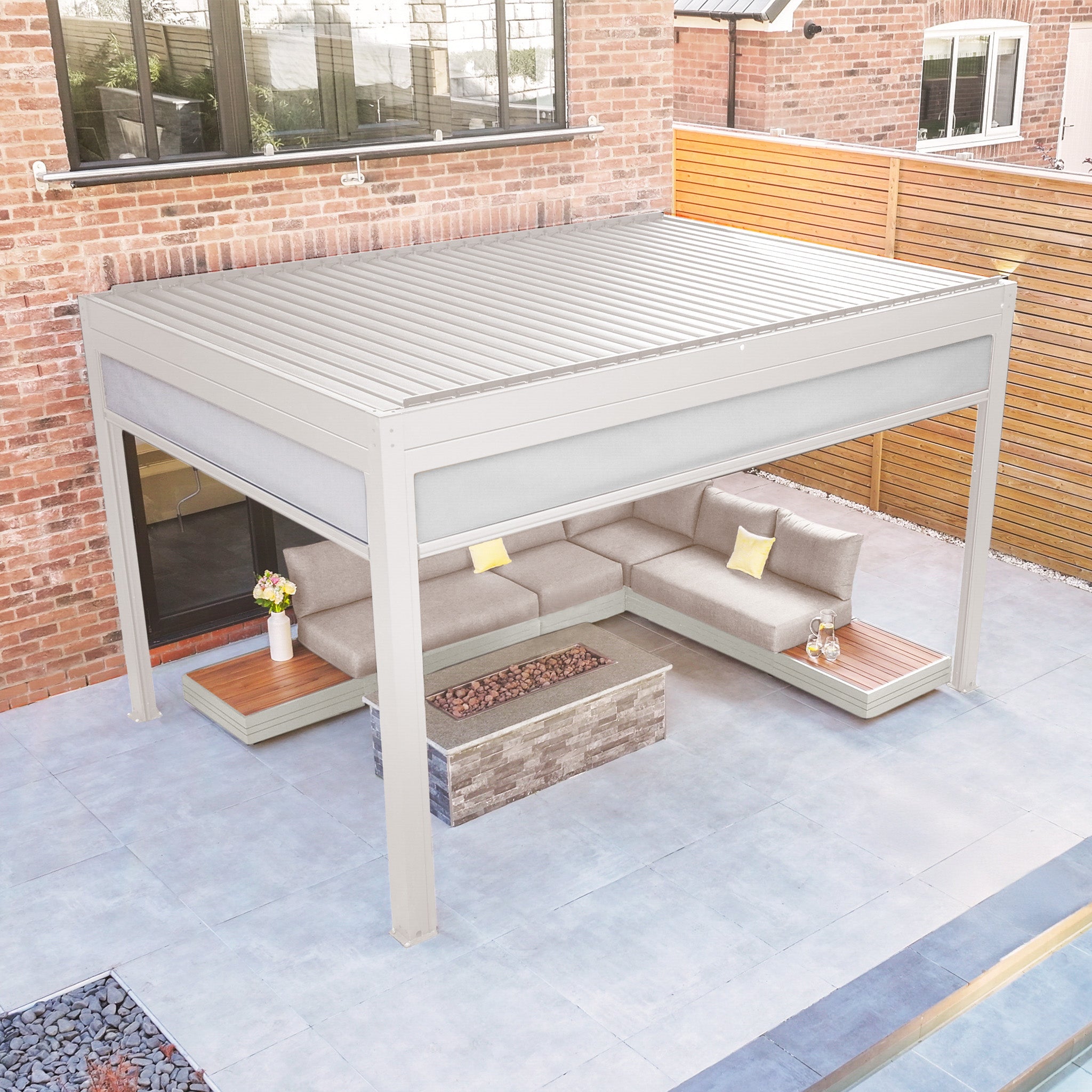 Contemporary patio with a PergoSTET Plus 3m x 4m Latte Rectangular Pergola featuring manual side blinds, LED lighting, outdoor sectional sofa, fire pit table, and potted flowers on tiled flooring.